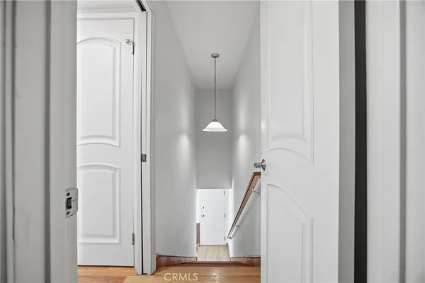 a view of a hallway with white walls and stairs
