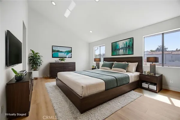 a bedroom with a large bed and a flat screen tv