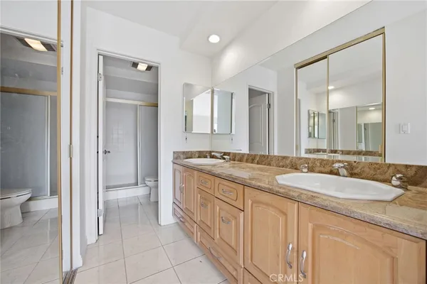 a spacious bathroom with a granite countertop sink mirror and a toilet