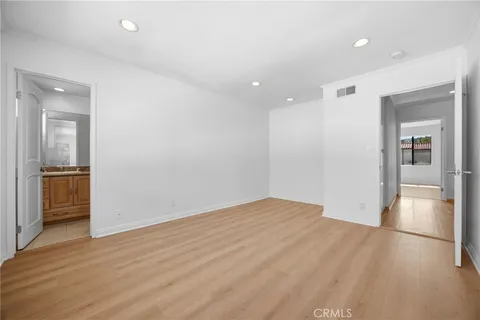 wooden floor in an empty room with a kitchen