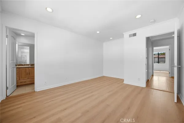 wooden floor in an empty room with a kitchen