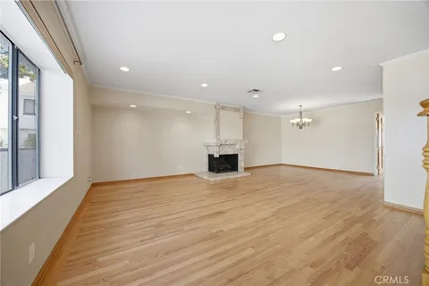 a view of empty room with wooden floor and window