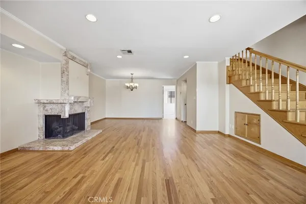 a view of empty room with wooden floor and fireplace