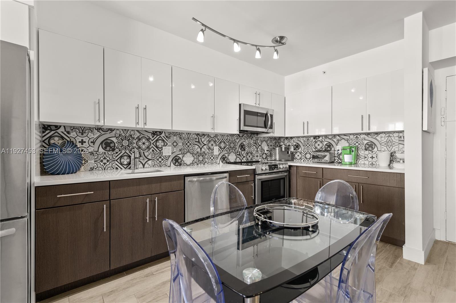 100 Lincoln Road, Unit 643 Miami Beach, FL 33139 - Photo 9 of 17 a kitchen with kitchen island stainless steel appliances a sink a stove a table and chairs