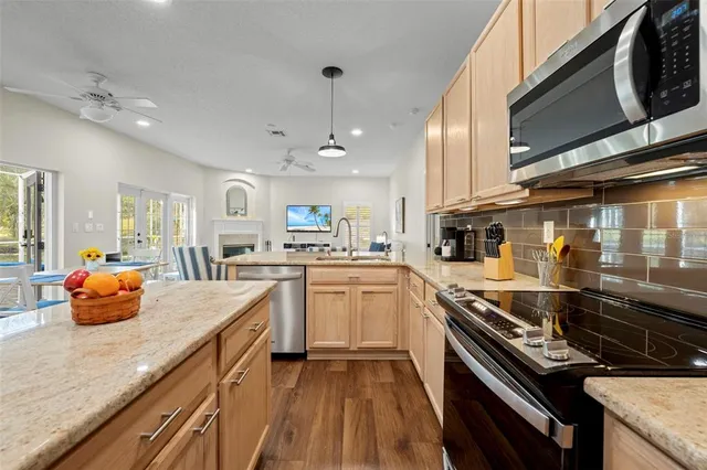 a kitchen with stainless steel appliances granite countertop a sink stove and refrigerator