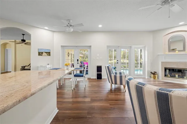 a living room with furniture a fireplace and a dining table with wooden floor