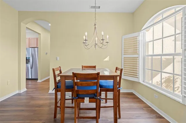 a view of a dining room with furniture a chandelier and wooden floor