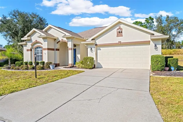 a view of house with garden and tall tress