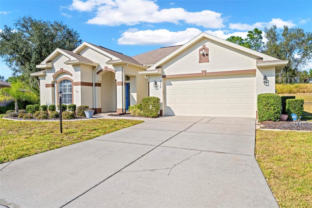 332 McIntosh Court Spring Hill, FL 34609 - Photo 8 of 54 a view of house with garden and tall tress