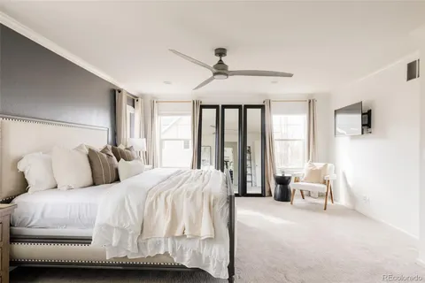 a bedroom with a bed and large windows
