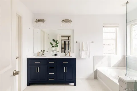 a bathroom with a tub a sink and mirror