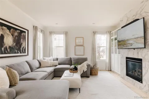 a living room with furniture a fireplace and a large window