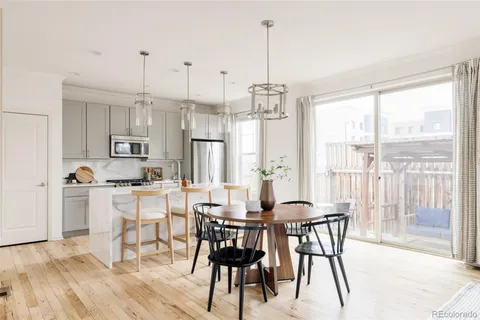 a view of a dining room and livingroom with furniture wooden floor a chandelier