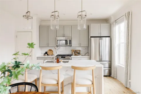 a kitchen with stainless steel appliances kitchen island granite countertop a refrigerator and a stove top oven