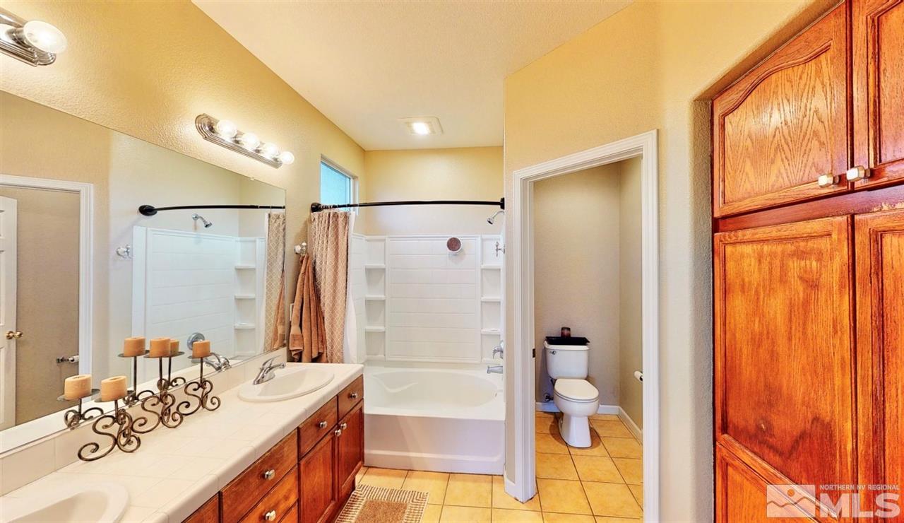 10615 Arbor Way Reno, NV 89521 - Photo 15 of 23 a bathroom with a granite countertop sink a toilet and shower