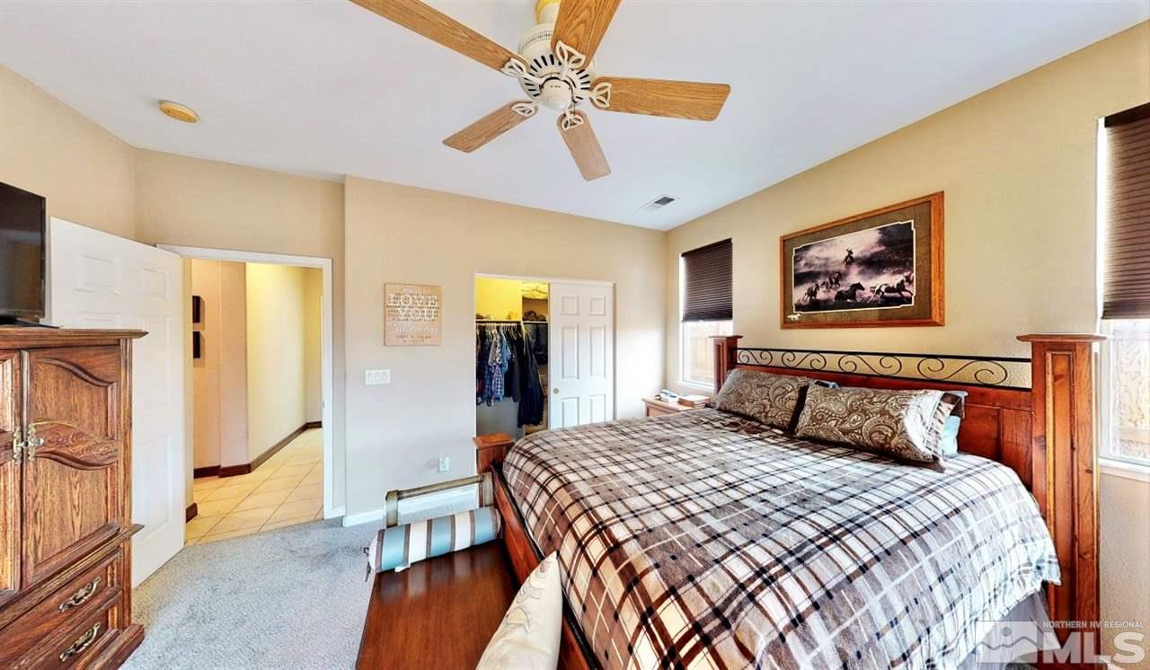 10615 Arbor Way Reno, NV 89521 - Photo 17 of 23 a bedroom with a large bed and a chandelier