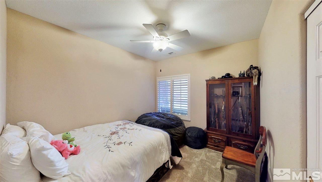10615 Arbor Way Reno, NV 89521 - Photo 18 of 23 a bedroom with a bed and a chandelier
