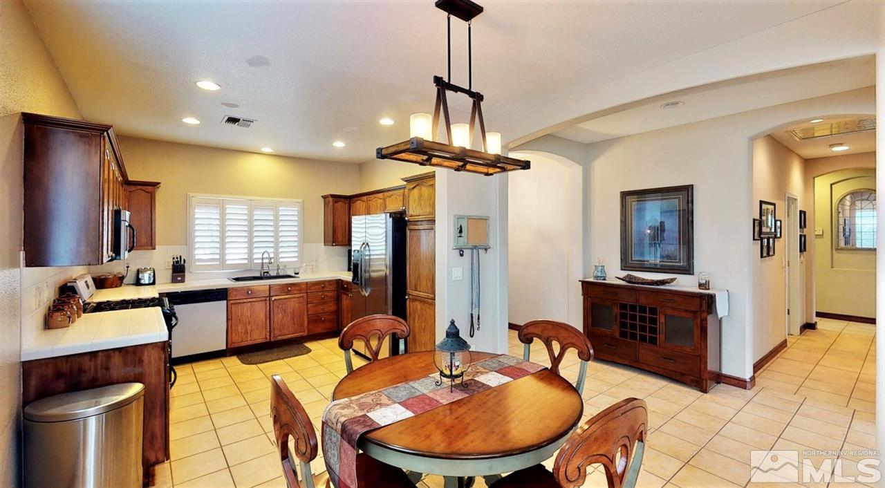 10615 Arbor Way Reno, NV 89521 - Photo 4 of 23 a large kitchen with sink refrigerator dining table and chairs