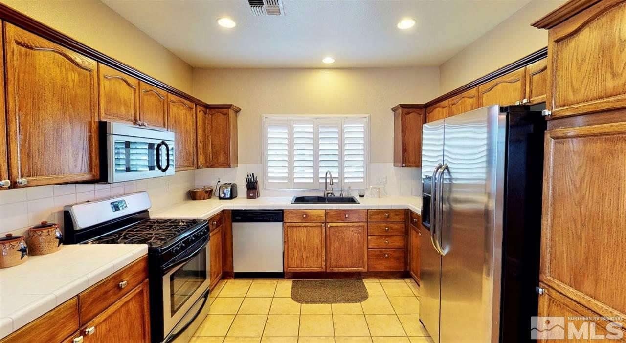 10615 Arbor Way Reno, NV 89521 - Photo 6 of 23 a kitchen with stainless steel appliances granite countertop a sink stove and refrigerator
