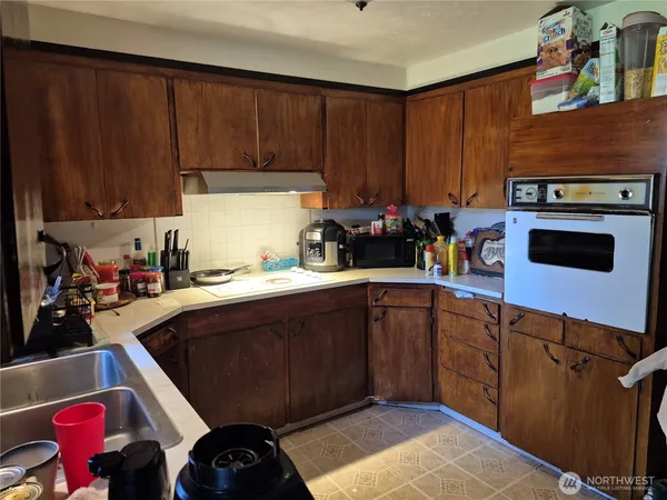 a kitchen with stainless steel appliances wooden cabinets and a stove top oven