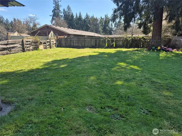 a view of a house with a big yard and large trees