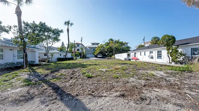 a view of a house with a yard and potted plants