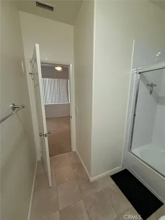 an empty room with closet and a ceiling fan