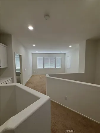 an empty room with windows and fan view