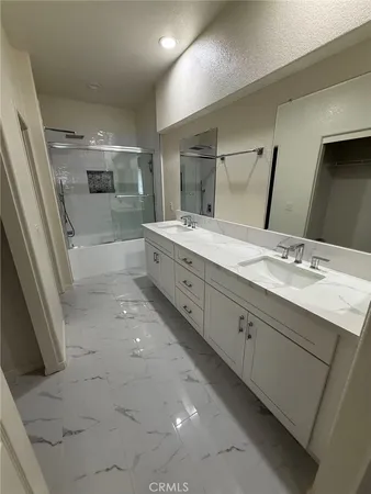 wooden view of a hallway with a glass door and a bathroom