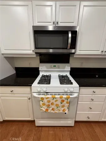 a kitchen with granite countertop wooden cabinets and stainless steel appliances