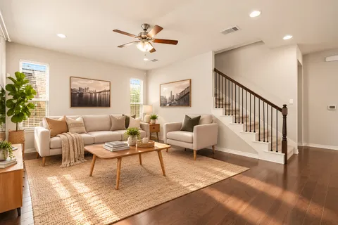 a living room with furniture and a ceiling fan