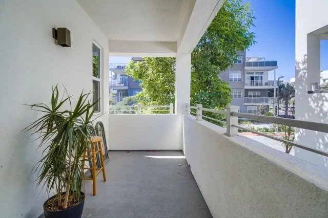 a white vase with flowers and a glass door