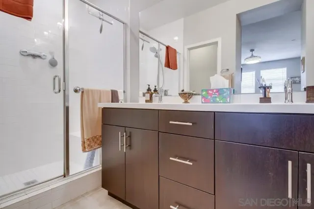 a bathroom with a sink vanity mirror and shower