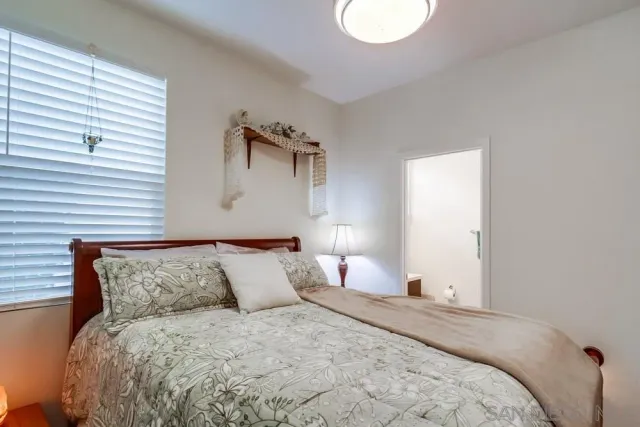 a bedroom with a bed and a refrigerator