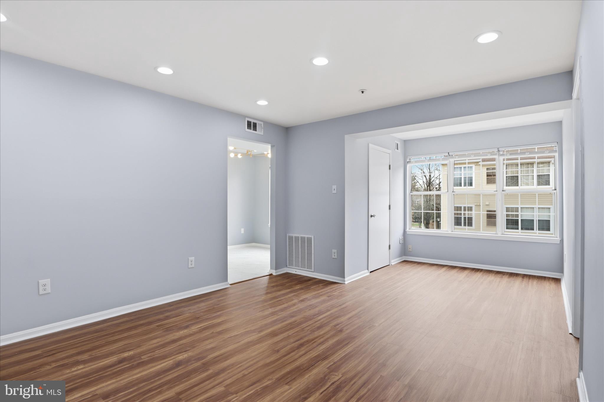14913 Cleese Court, Unit C Silver Spring, MD 20906 - Photo 6 of 35 a view of an empty room with wooden floor and a window