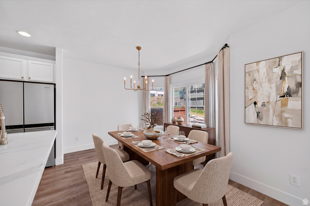 14771 Haddington Road Draper, UT 84020 - Photo 16 of 44 Bright dining area featuring a bay window, wood-finish flooring, and a modern chandelier