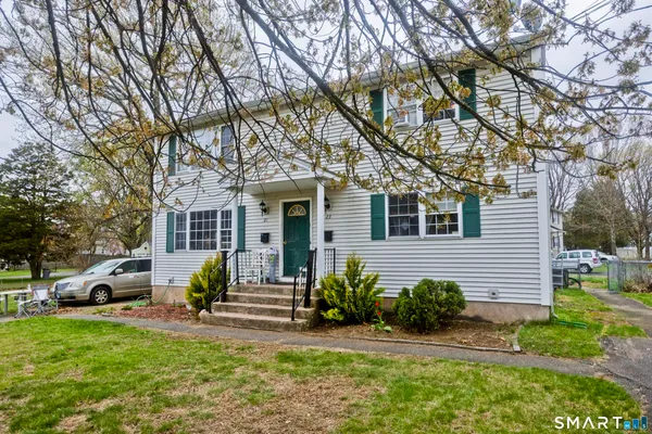 a front view of a house with a yard and tree s