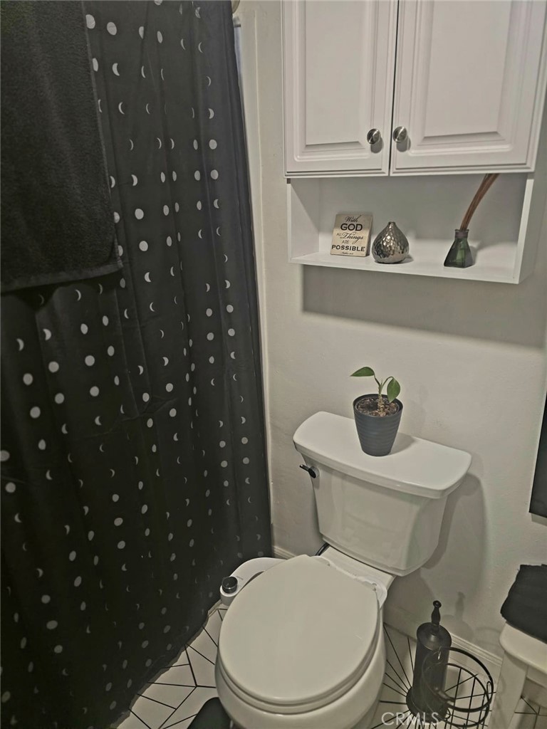 15621 Beach Boulevard, Unit 28 Huntington Beach, CA 92647 - Photo 26 of 27 a white toilet sitting next to a bathroom sink