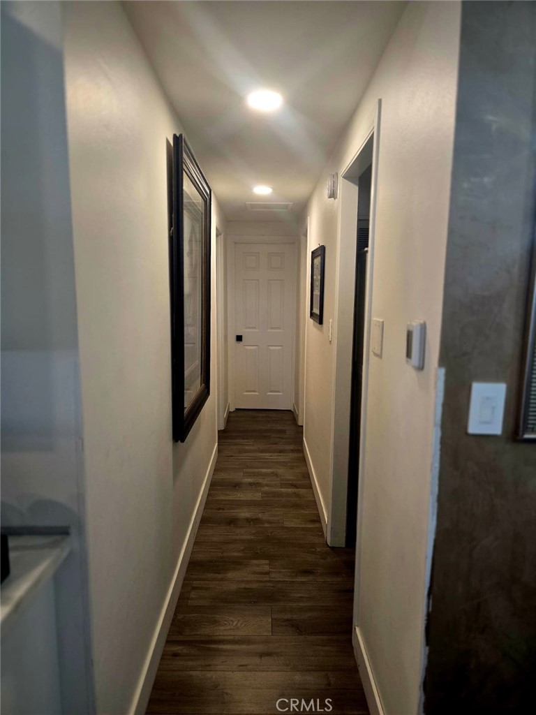 15621 Beach Boulevard, Unit 28 Huntington Beach, CA 92647 - Photo 27 of 27 a view of a hallway with wooden floor and stairs