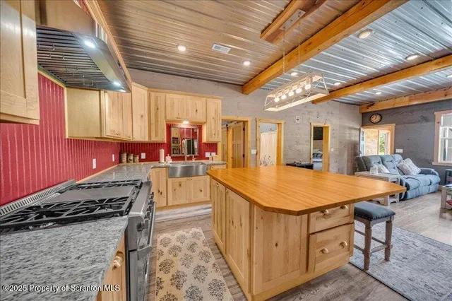 a kitchen with stainless steel appliances granite countertop sink stove and refrigerator