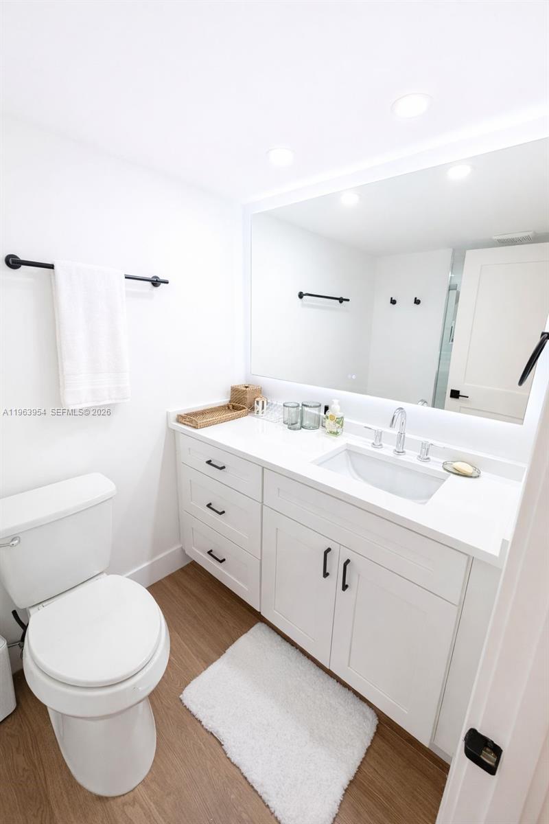 1541 Brickell Avenue, Unit B1504 Miami, FL 33129 - Photo 19 of 31 a bathroom with a toilet a sink a mirror and a shower