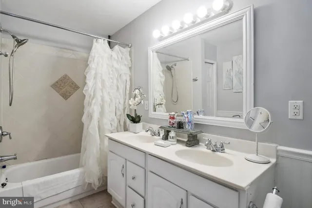 a bathroom with a double vanity sink mirror double and shower
