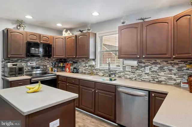 a kitchen with stainless steel appliances granite countertop a sink stove and microwave