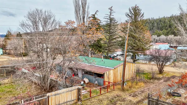 a view of a house with a yard and large tree