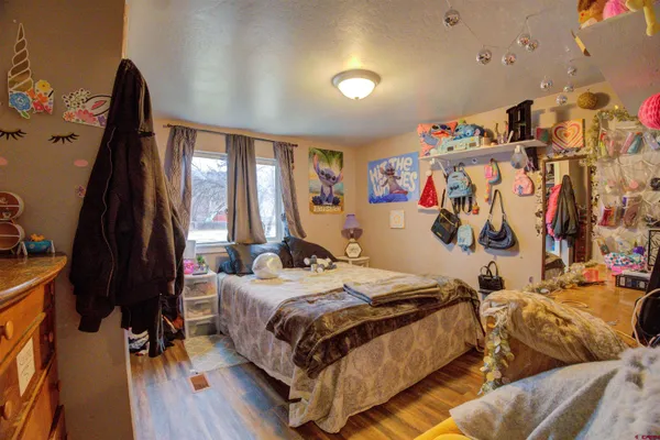 a bedroom with a bed and a wooden floor