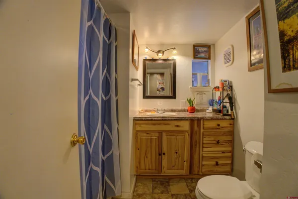 a bathroom with a granite countertop sink toilet and shower