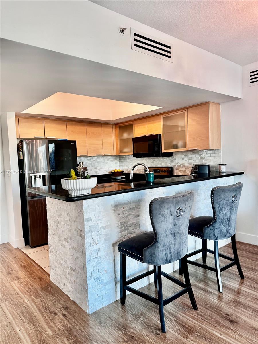 140 South Dixie Highway, Unit 921 Hollywood, FL 33020 - Photo 11 of 30 a kitchen with stainless steel appliances granite countertop a stove top oven a sink a dining table and chairs