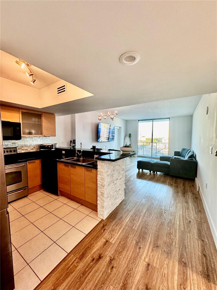 140 South Dixie Highway, Unit 921 Hollywood, FL 33020 - Photo 10 of 30 a kitchen with stainless steel appliances kitchen island granite countertop a stove a sink and a refrigerator