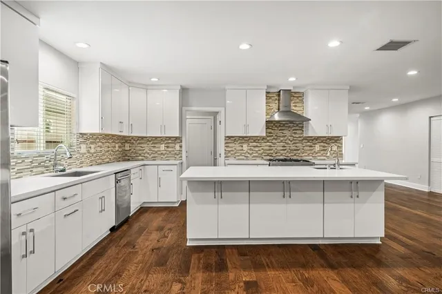 a kitchen with stainless steel appliances granite countertop a stove and white cabinets