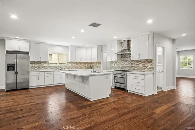 a kitchen with white cabinets and stainless steel appliances
